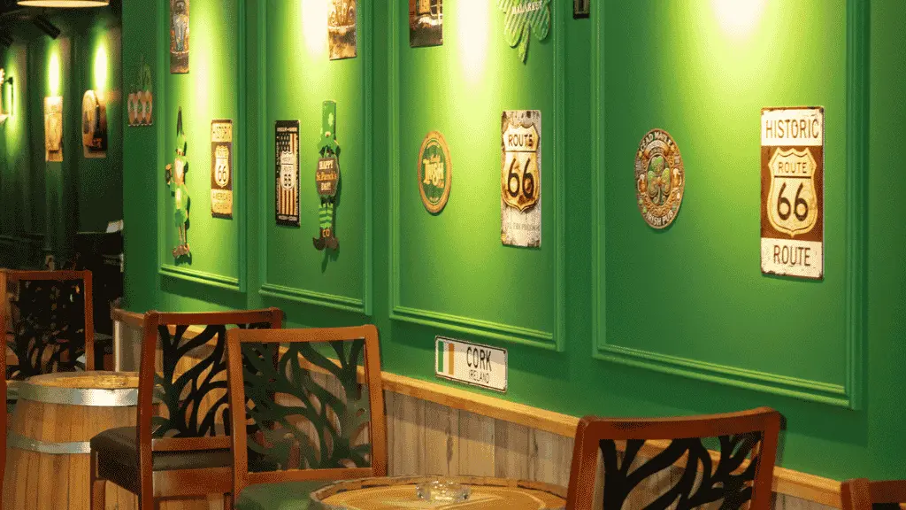 Vintage road and pub signs on a green wall at Irish Inn, beside a barrel table