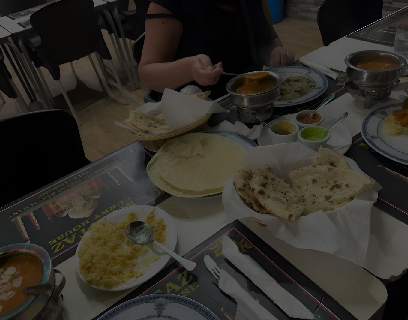 A table at Mumtaz Curry House with naan, chapati, rice and curries